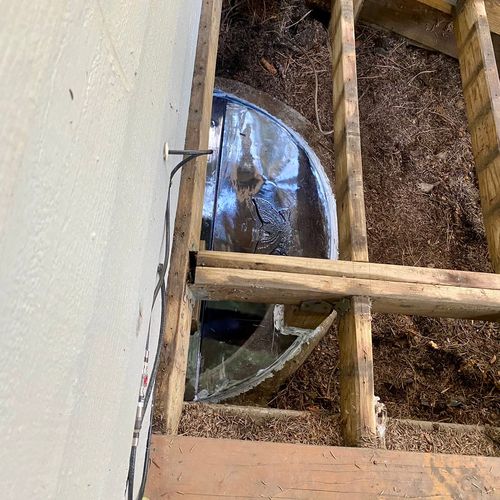 Window well cover installed under existing deck to