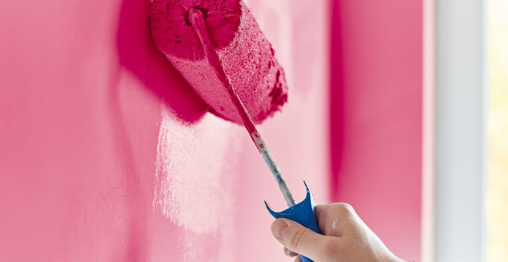 painter adding second coat of paint to wall