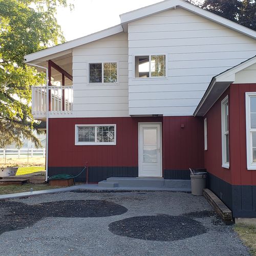 Painted skirt of house and graveled parking