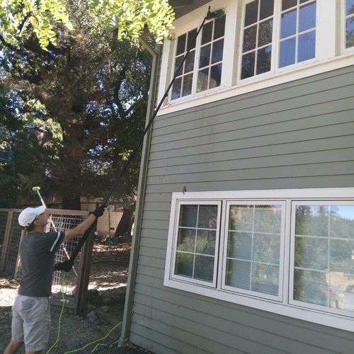 Expertly cleaning 2nd story windows with the water