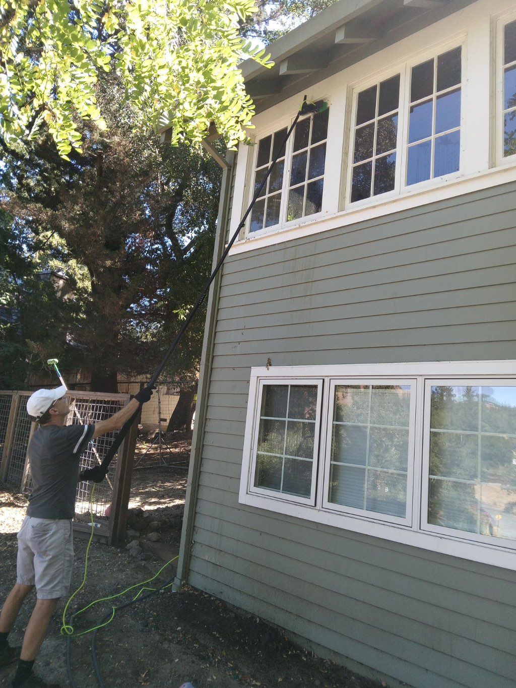 Expertly cleaning 2nd story windows with the water