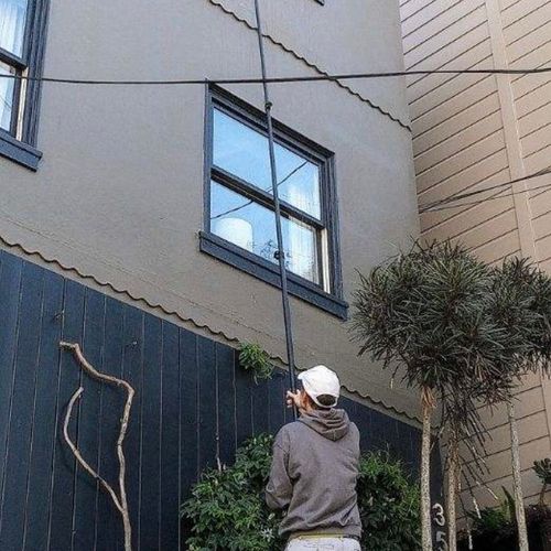 Cleaning 3rd story windows with the water-fed pole