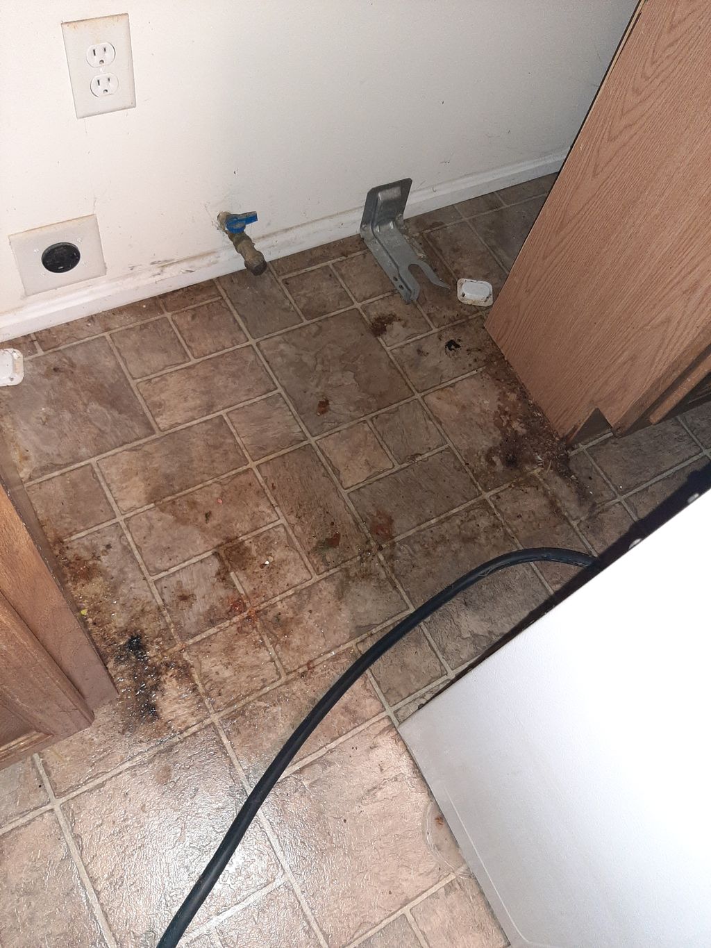 Before picture of floor cleaning behind an applian