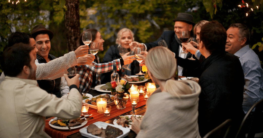 people gathering and eating around a dinner table