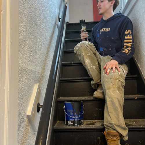 Connor painting hand rail in duplex.