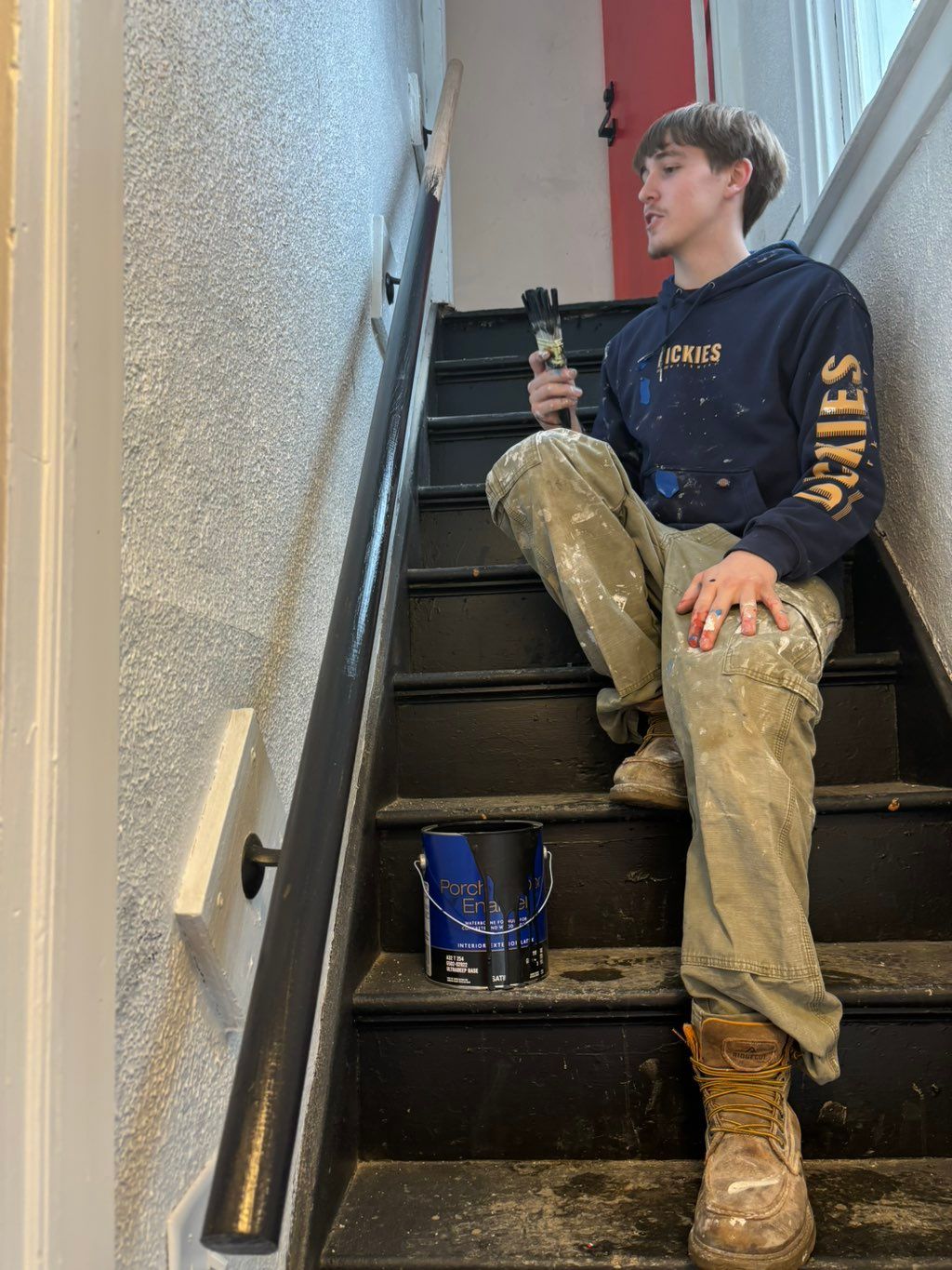 Connor painting hand rail in duplex.