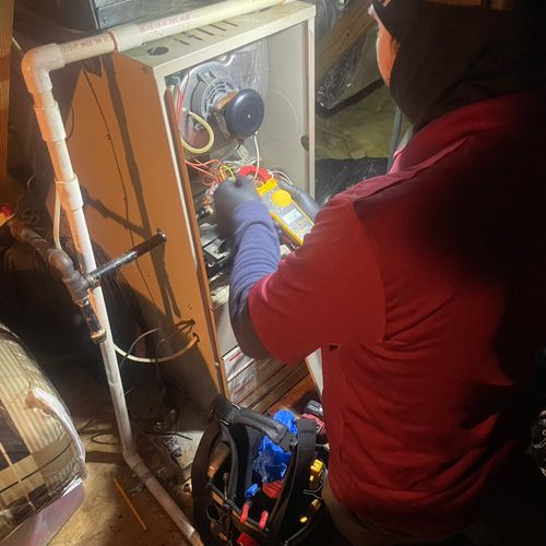 Our technician working in a cold attic repairing a