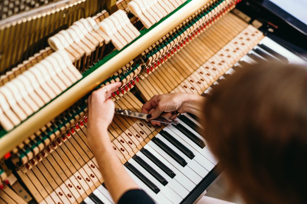 Our piano technician Rachel working on an upright 