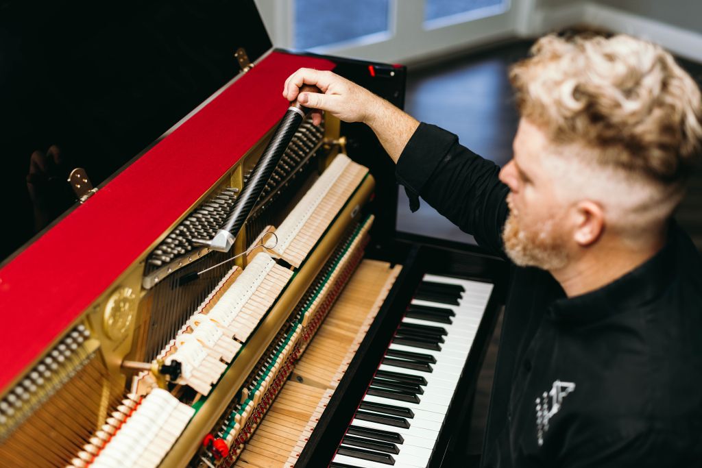 Our piano technician Timothy tuning an upright pia