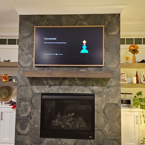 Frame TV on tile, above fireplace