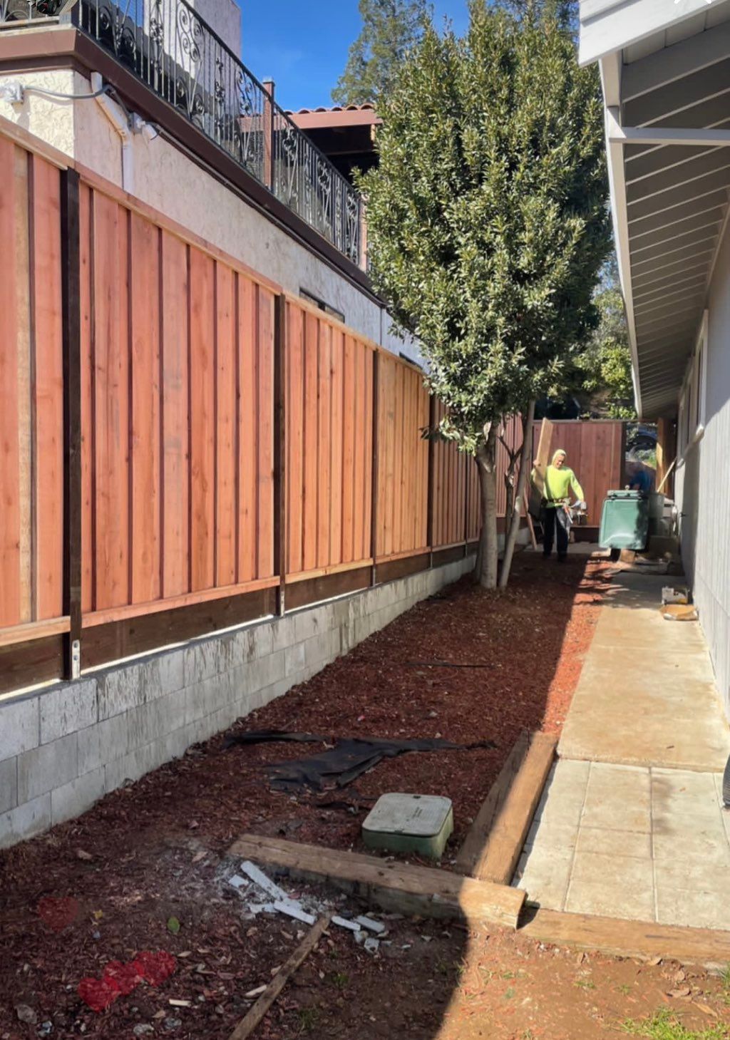 CMU retaining wall with new 6 foot high redwood fe