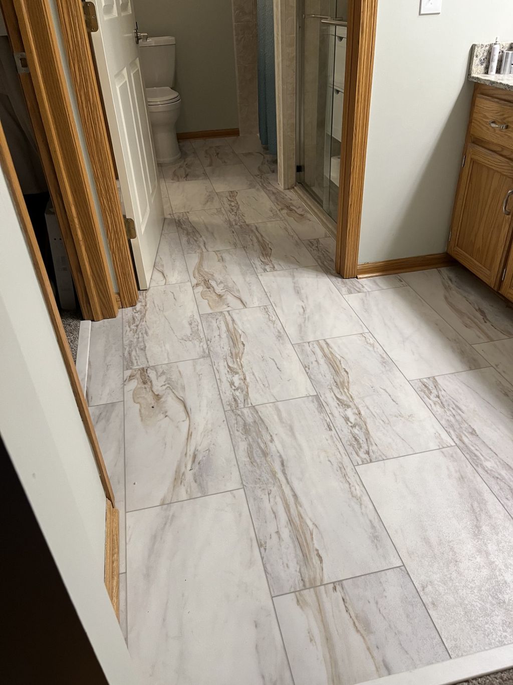 Marble look Luxury Vinyl tile installed in bathroo