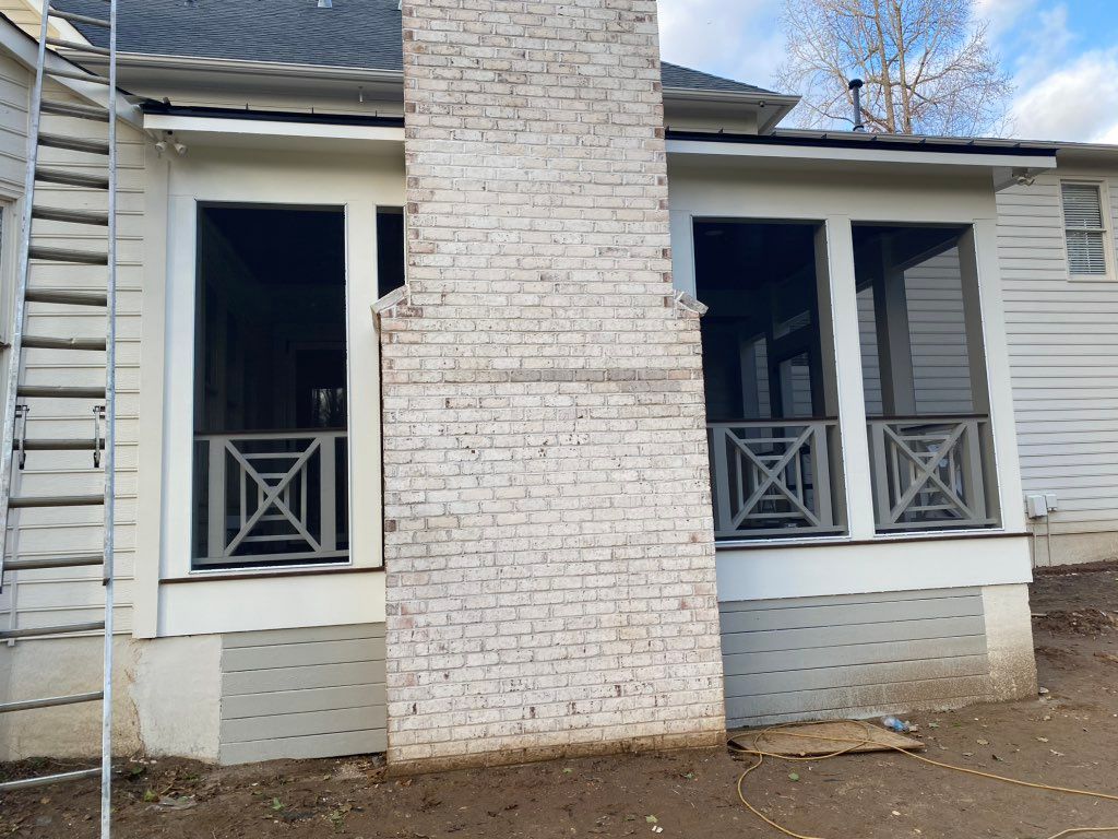 Screen in covered porch with outdoor fireplace