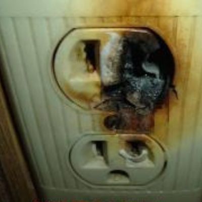 This electrical outlet shows signs of burning. Thi