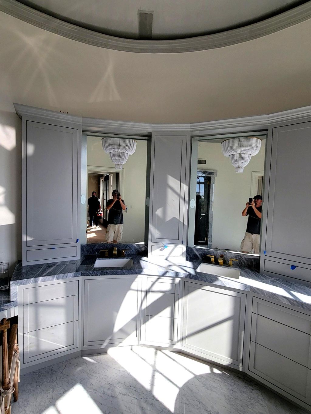 Elegant custom mirrors set into curved cabinetry—r