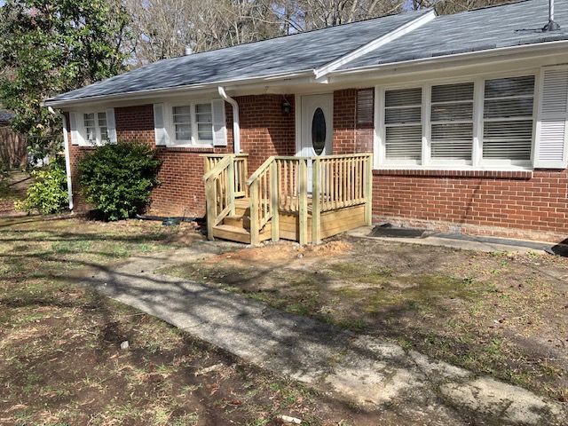 covered sunken concrete steps with a wood porch