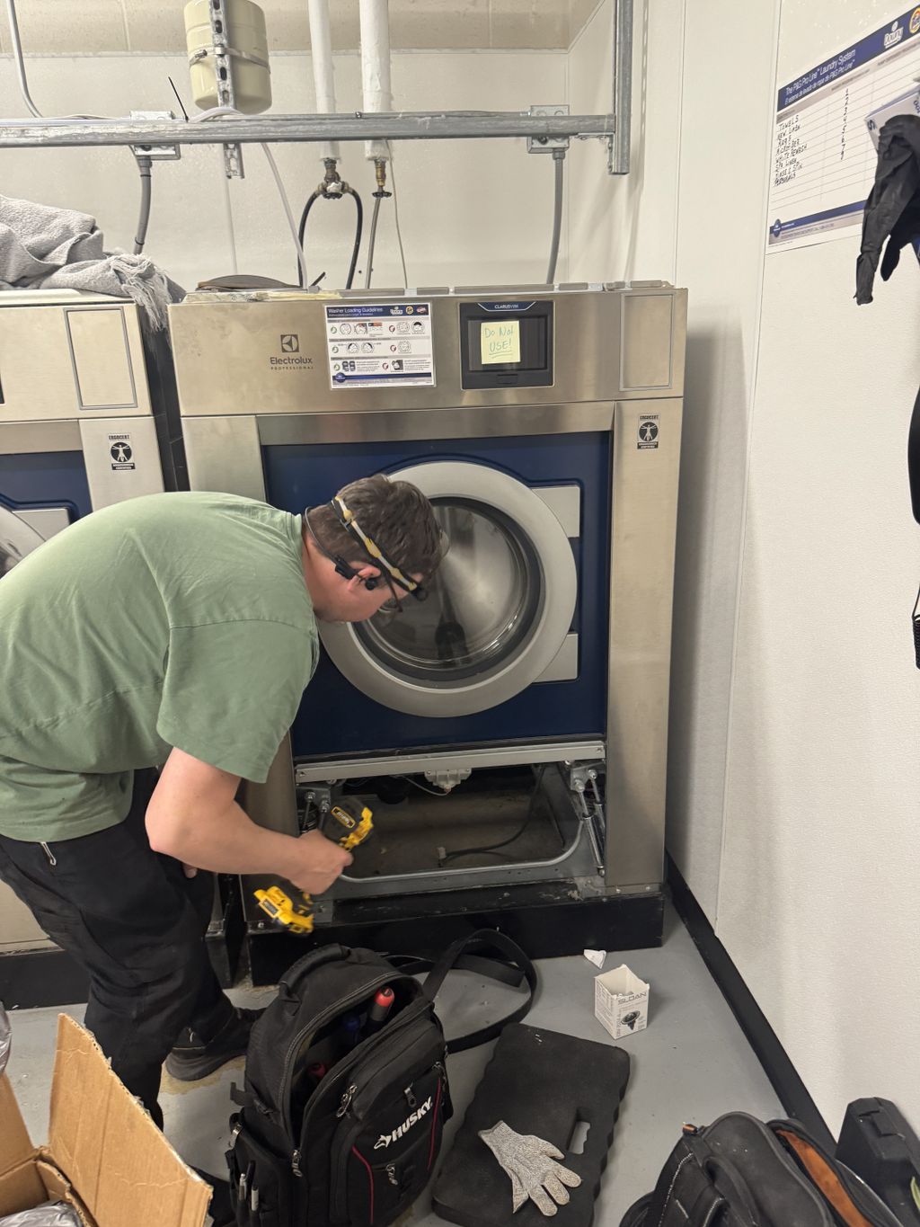 Tech working on commercial washing machines