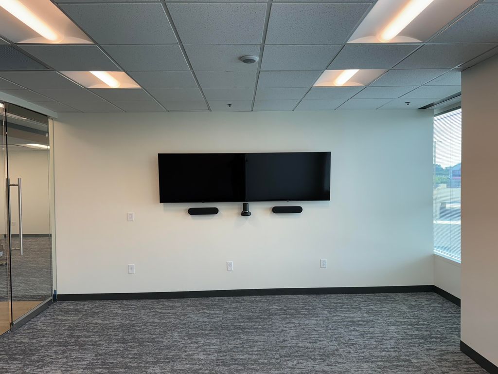 2 TVs mounted side by side in a conference room in