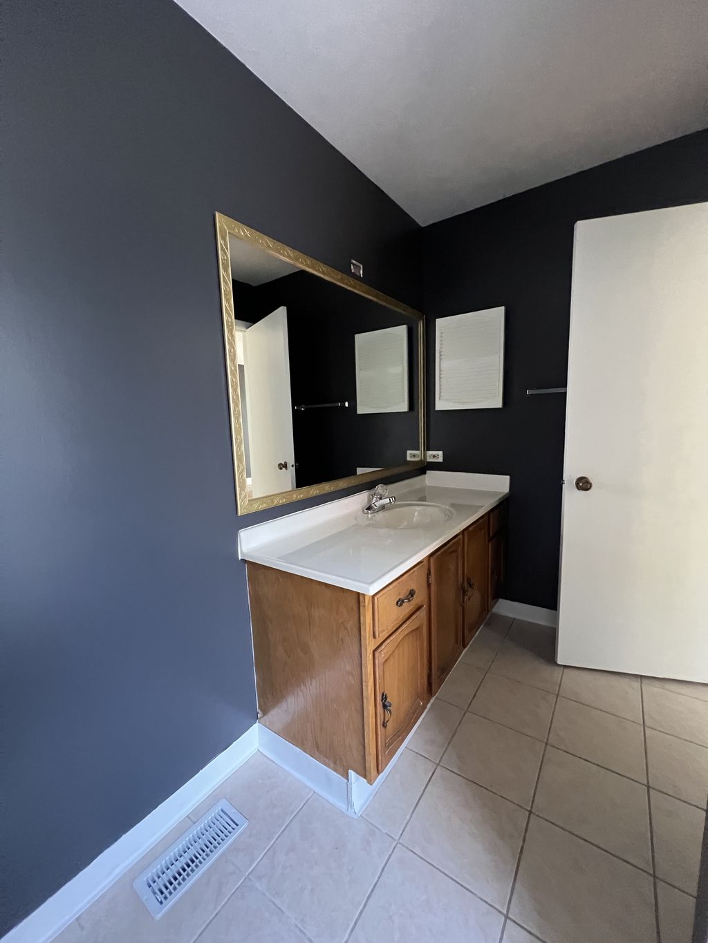 Gold-painted mirror frame in master bath