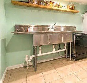 Installation of 3-bay commercial sink. 
