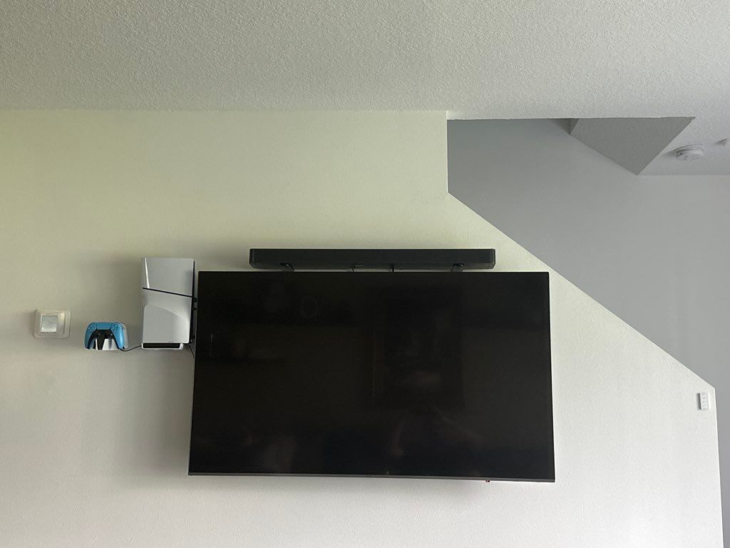TV setup with soundbar and PlayStation mounted. Pr