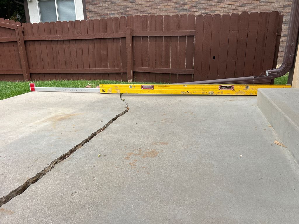 Concrete patio cracked due to settlement of the sl