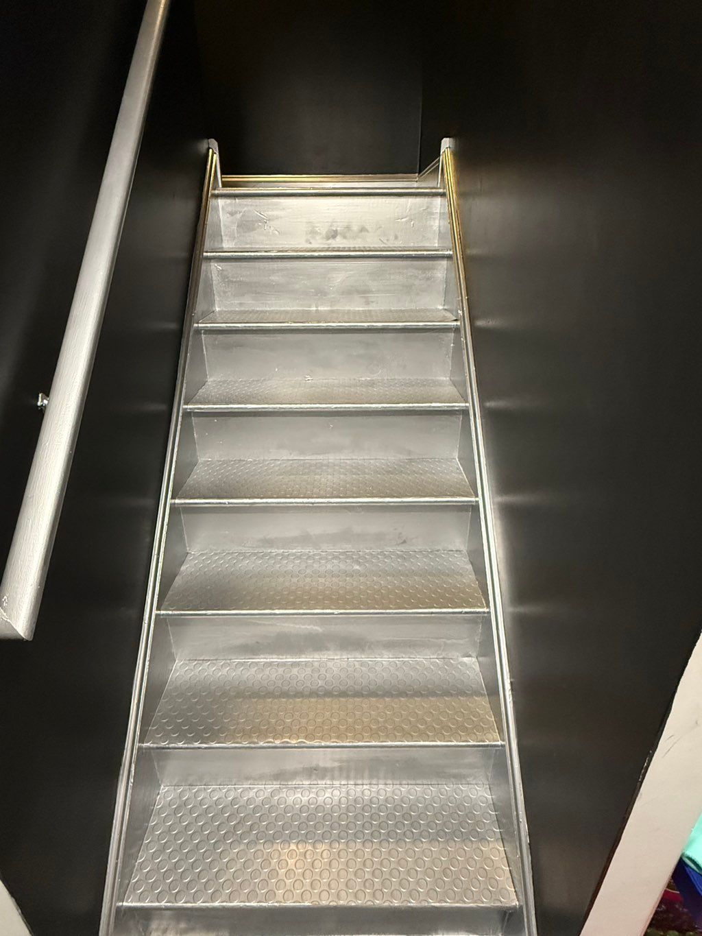 Painted walls and ceiling black, railing and steps